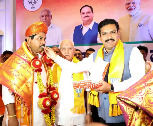 आर अशोक को विपक्षी दल का नेता चुने जाने पर ​मिठाई खिलाते बीवाई विजेंद्र