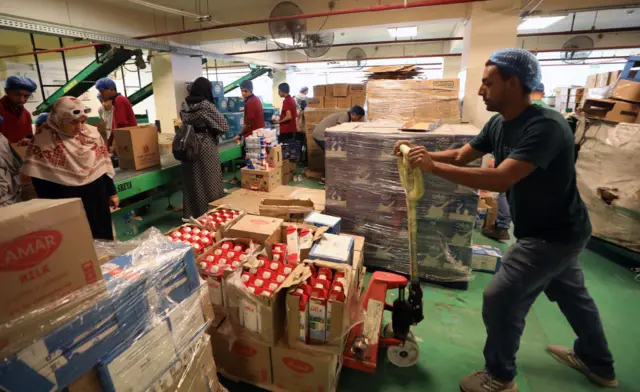 متطوعون يعدون المواد الغذائية للفلسطينيين في قطاع غزة، في أحد المستودعات في القاهرة الجديدة، مصر، 22 نوفمبر/تشرين الثاني 2023.