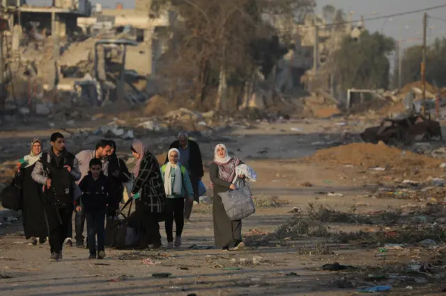 عائلة فلسطينية تحاول الوصول إلى منزلها المدمر في غزة