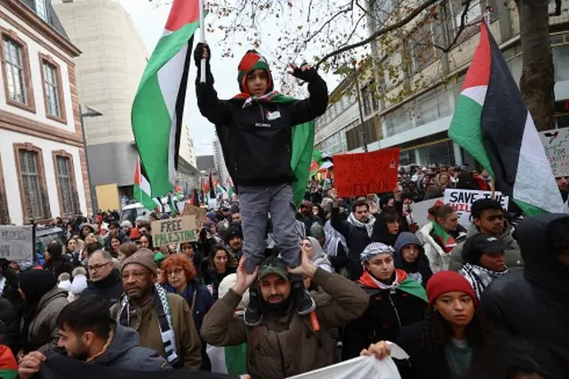صبي يحمل العلم الفلسطيني وهو يقف على أكتاف متظاهر خلال مظاهرة لدعم الفلسطينيين في غزة بفرانكفورت في ألمانيا