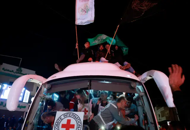 أسرى فلسطينيون أطلق سراحهم يلوحون بالأعلام عند مغادرتهم سجن عوفر العسكري الإسرائيلي