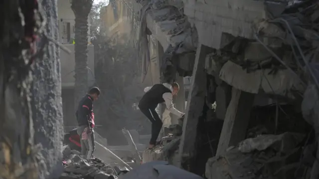 فلسطينيون يبحثون عن ضحايا وناجين بين أنقاض منزل مدمر جراء الغارات الجوية الإسرائيلية