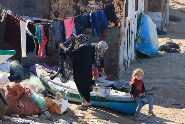 امرأة فلسطينية تعلق ملابسها على شاطئ في دير البلح وسط قطاع غزة في 30 نوفمبر 2023