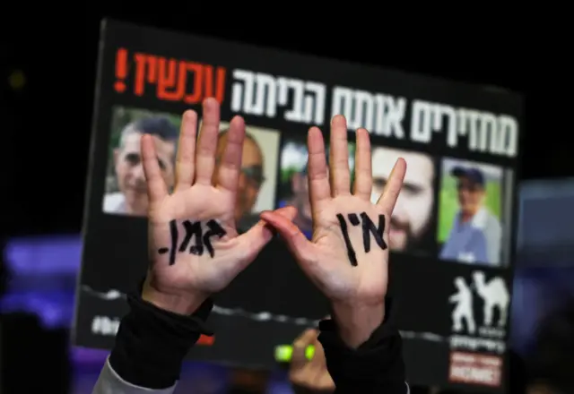 На ладонях у женщины написано на иврите «Времени нет»