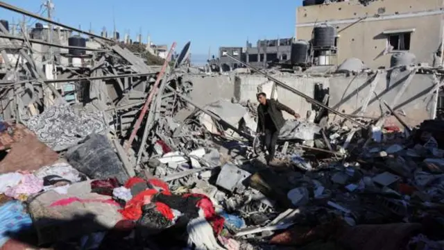 رجل فلسطيني وسط أنقاض منزل دمره القصف