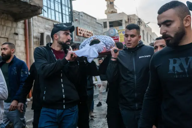 فلسطينيون يحملون جثمانا.