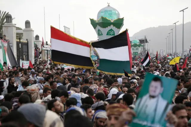 متظاهرون يرفعون الأعلام الفلسطينية واليمنية ولافتات مؤيدة للحوثيين خلال احتجاج للتضامن مع الفلسطينيين في صنعاء اليمن بتاريخ 15 ديسمبر/كانون الأول 2023.