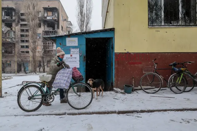 Женщина с велосипедом у бомбоубежища в Гуляйполе.
