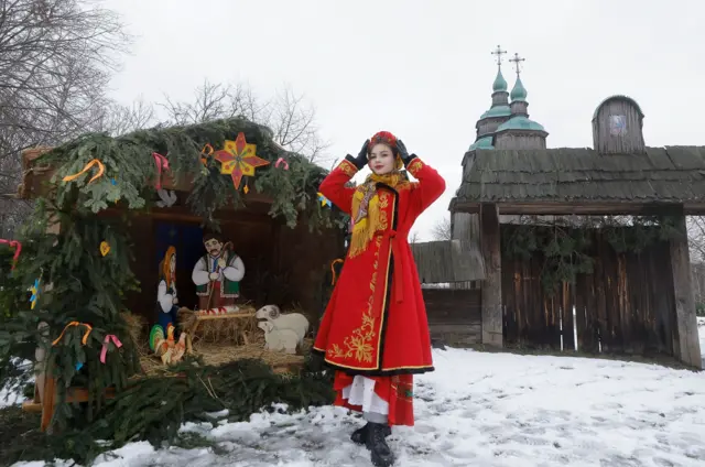 Украинская женщина в традиционном наряде рядом с рождественским вертепом в селе Пирогово, неподалеку от Киева