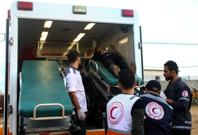 جمعية الهلال الأحمر الفلسطيني يحملون شابا مصابا شرق مدينة غزة