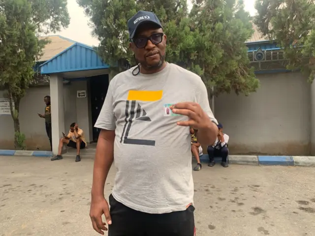Paul hold im PVC as e dey wait for voting to start for im polling unit