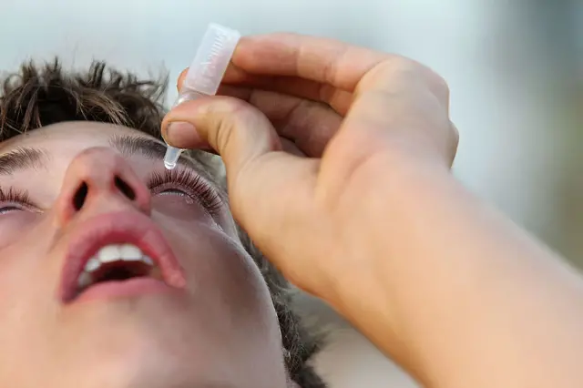 رجل يضع قطرة عين في عينه