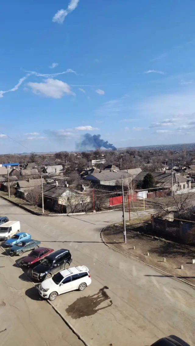 вид деревни и дым от крушения самолета
