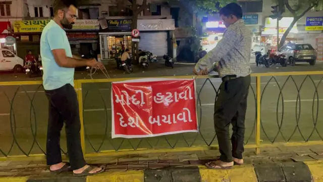 पोस्टर लगाते आप कार्यकर्ता