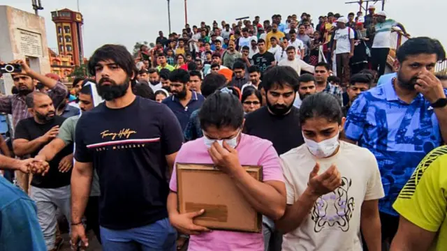 हरिद्वार स्थित हर की पौड़ी पर अपने पदकों के साथ भारतीय पहलवान