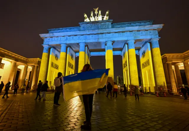 В первую годовщину начала российского вторжения Бранденбургские ворота в центре Берлина подсветили цветами украинского флага