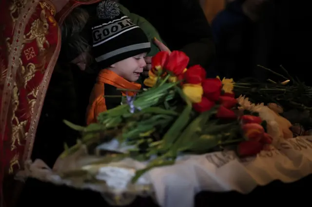Мальчик плачет на похоронах детей в Украине