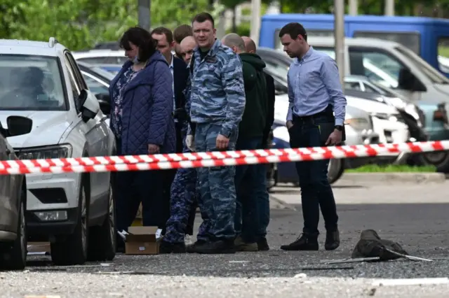 Сотрудники правоохранительных органов возле поврежденного многоэтажного жилого дома после сообщения об атаке беспилотника в Москве 30 мая 2023 года