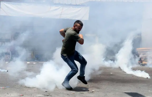 इसराइल के हमले से बचता हुआ एक फ़लस्तीनी युवा