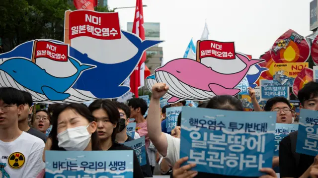 韩国反对日本福岛排放核废水群众在首尔集会上举起鲸鱼造型标语牌（15/7/2023）