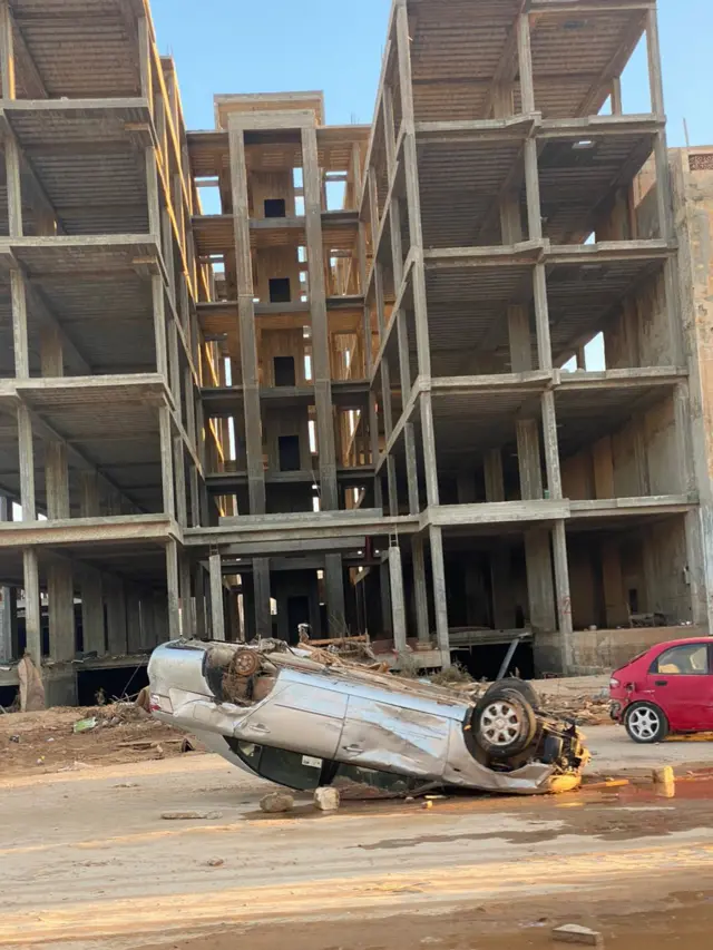 سيارة منقلبة أمام إحدى البنايات