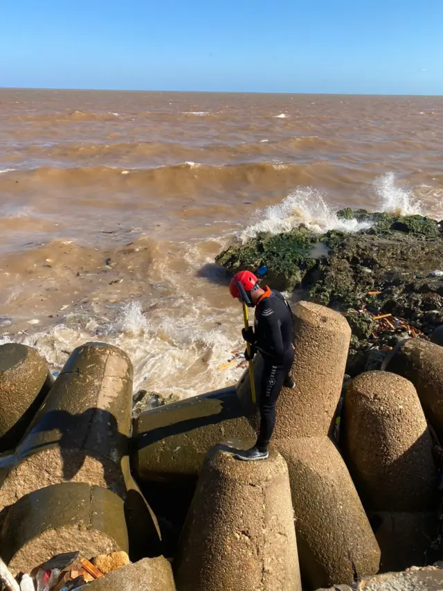 منقذ يقف على شاطئ المدينة فيما يبدو أنه عملية بحث