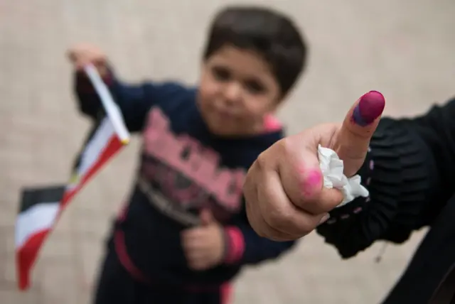 ناخب مصري يُظهر إبهامه المُغطى بالحبر في الانتخابات الرئاسية المصرية في 2018