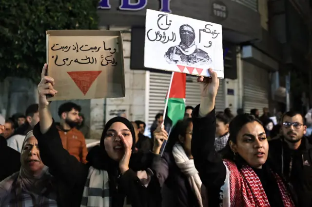 مشاركون في  المسيرة يرفعون صورة أبو عبيدة، المتحدث باسم كتائب القسام.