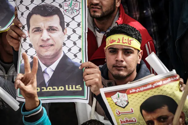 فلسطينيون يرفعون صور دحلان في مظاهرة بمدينة غزة في أواخر عام 2014، للتعبير عن رفضهم محمود عباس رئيس السلطة الفلسطينية.