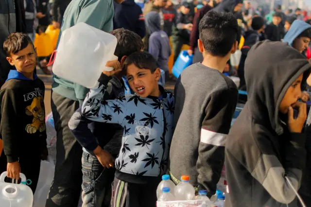 طفل فلسطيني يحمل وعاء وينتظر الحصول على ماء