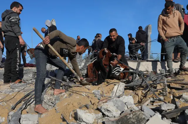 فلسطينيون يبحثون عن ضحايا في موقع غارة إسرائيلية في رفح بجنوب قطاع غزة في 7 يناير/كانون الثاني 2024