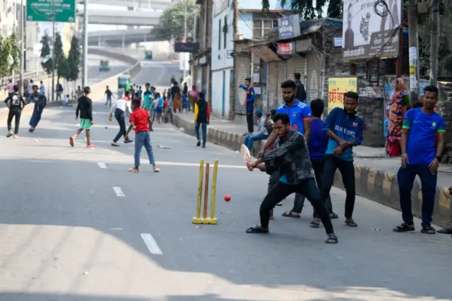 ফাঁকা রাস্তায় ক্রিকেট খেলছে অনেকে।