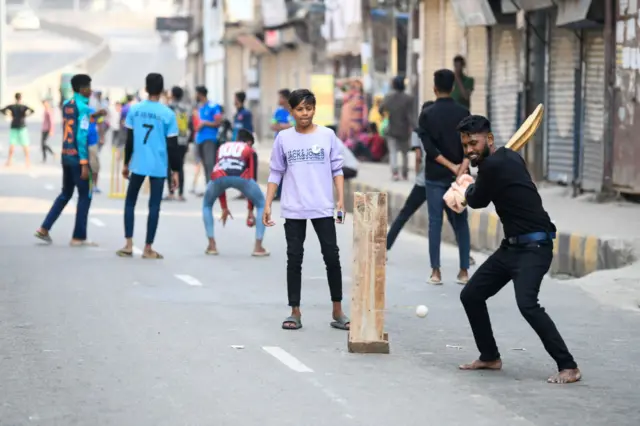 ফাঁকা রাস্তায় ক্রিকেট খেলছে শিশুরা।