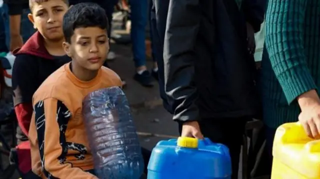 أطفال يصطفون انتظارا للحصول على مياه للشرب في رفح
