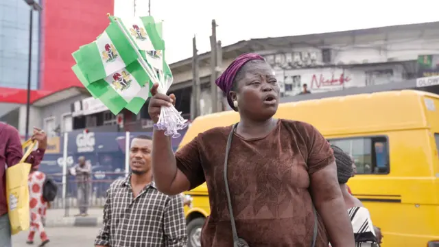 Nigerian woman hold kontri flags for protest ground
