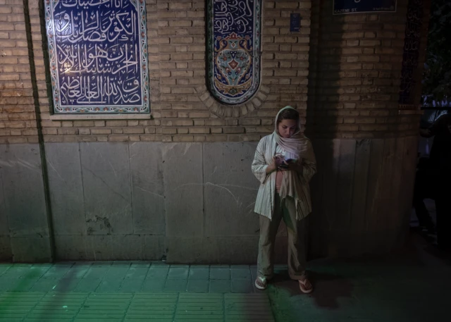 زنی در ایران در حال بررسی موبایلش