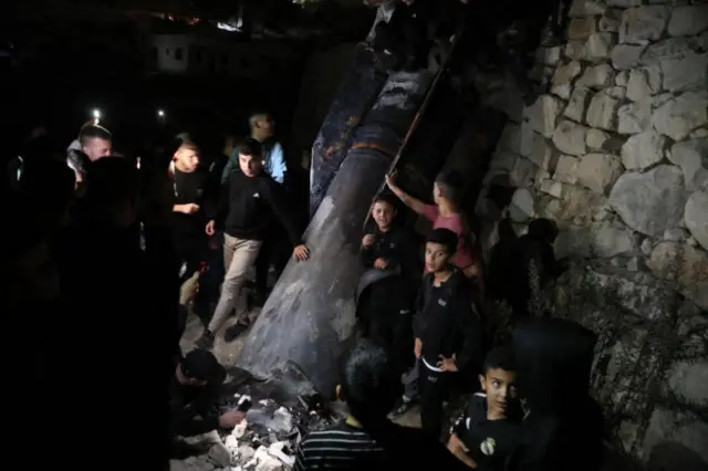 فلسطينيون يفحصون صاروخا سقط على الضفة الغربية