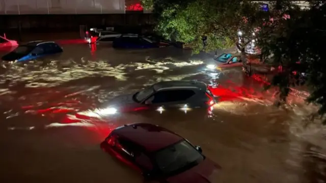 स्पेन में आई भीषण बाढ़ के बाद पानी में डूबी हुई गाड़ियां