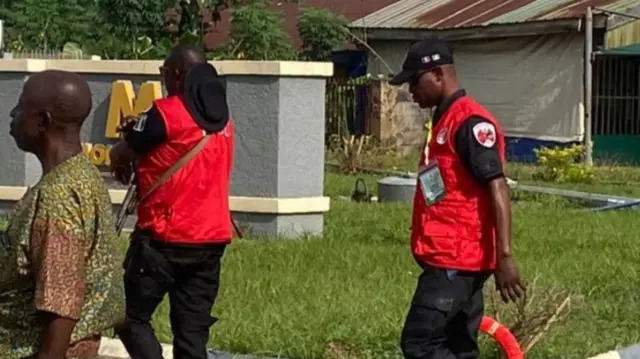 EFCC men wearing red jacket holding gun