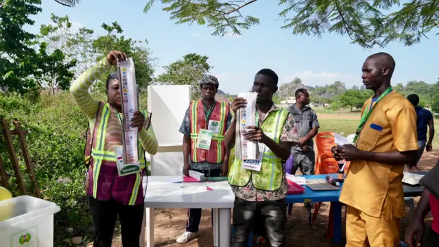 Woman hold ballot paper for pipo to see