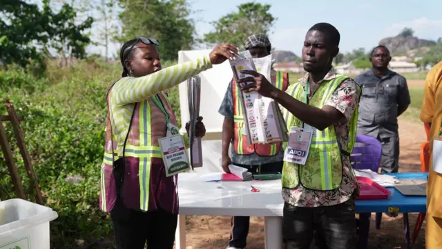 One woman dey hold ballot paper for counting