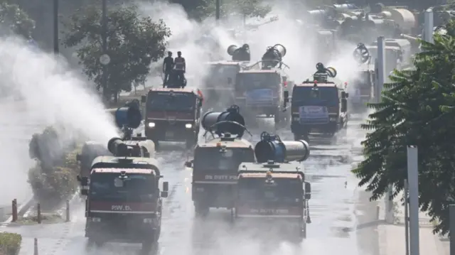 दिल्ली की सड़कों पर पानी का छिड़काव करते एंटी स्मॉग वाहन