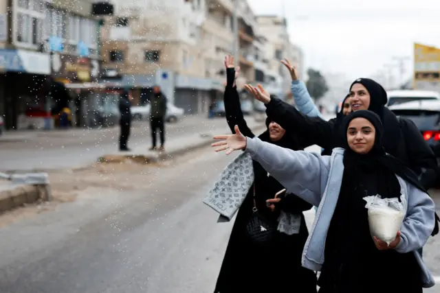 فتيات يستقبلن النازحين العائدين إلى مدينة صور، صباح الأربعاء، بنثر حبات الأرز