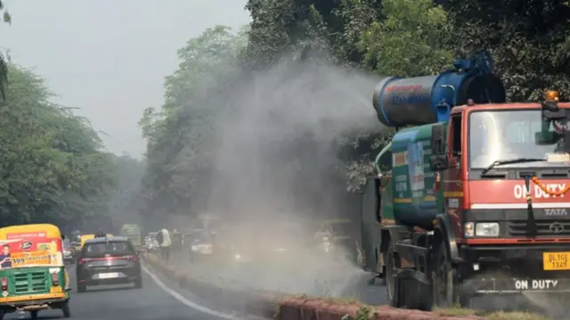 दिल्ली की सड़कों पर हो रहा पानी की छिड़काव