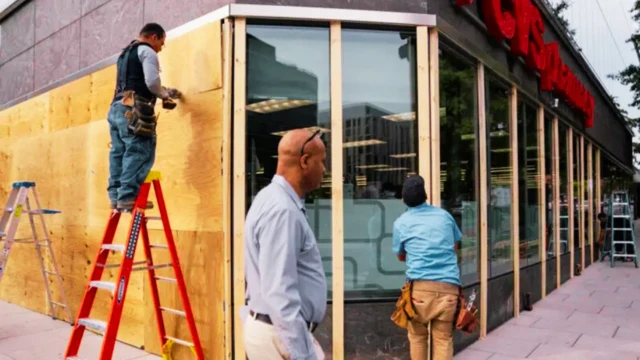 A man climb ladder wit anoda man wit glass ontop im head