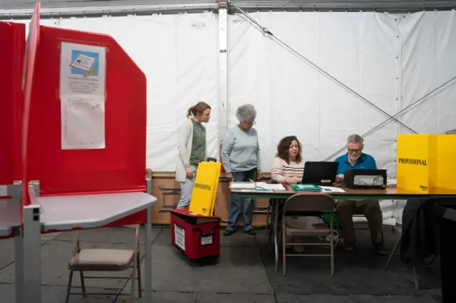 Election workers prepare a voting tent the day before Election Day in Burnsville