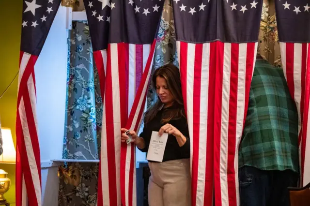 Residents of Dixville Notch cast dia ballots for di US election for midnight for di living room of di Tillotson House for di Balsams Grand Resort, e mark di first votes for diUS election, for Dixville Notch, New Hampshire on 5 November 2024