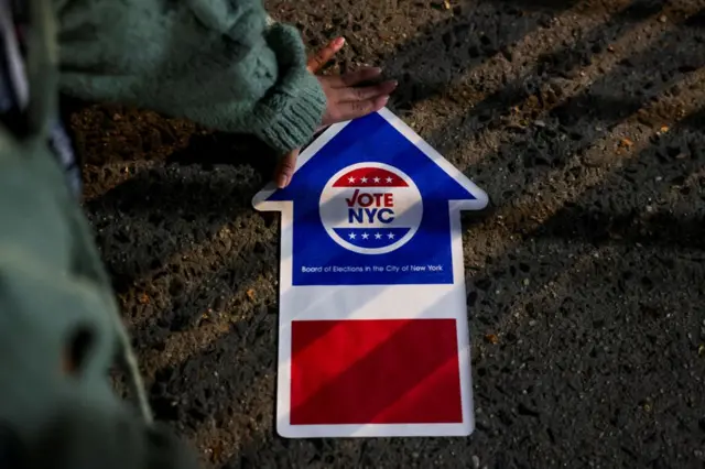 One pesin touch one election sign, on Election Day for di US presidential election for Manhattan, New York City, 5 November 2024