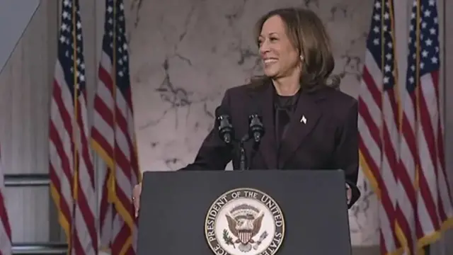 Kamala Harris sorrindobaixar pix bet apkpalanque, com bandeiras dos EUA atrás