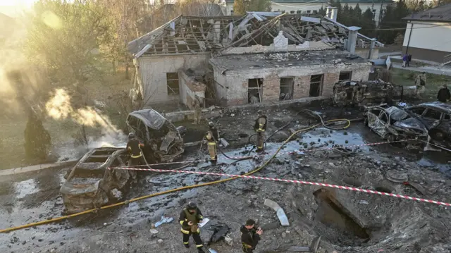 Разрушенный онкологический диспансер в Запорожье. Перед зданием воронка, вокруг спасатели
